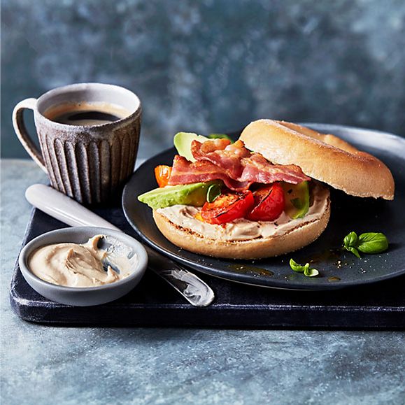 Marmite® cream cheese bagel with roasted tomatoes, avocado, streaky bacon and a cup of coffee