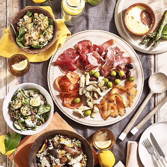 A garden table filled with charcuterie and salads