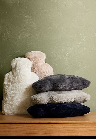 Selection of cream, pink and grey faux-fur hot-water bottles. Go to the Cosy Shop