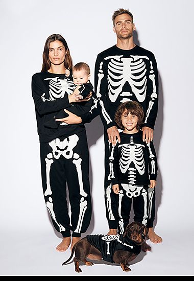 Family wearing matching skeleton pyjamas. Shop Halloween outfits 