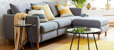 Grey corner sofa with striped cushions and rug