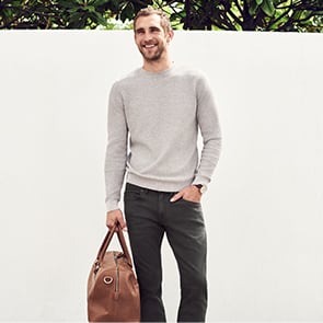 Man wearing jeans holding a bag