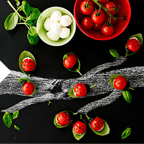 Cherry tomato ladybirds sitting on basil leaves