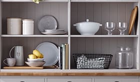 Grey sideboard with crockery and linens