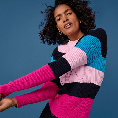 Woman wearing a blue, pink and navy striped jumper. Shop women’s knitwear 