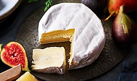 Wheel of Collection luxury truffle-filled brie with a wedge cut out