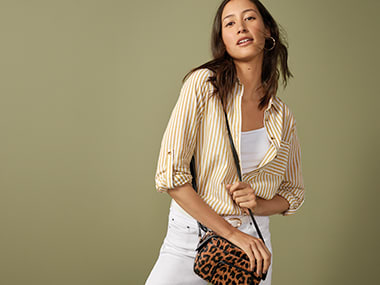 Woman wearing a striped shirt, white denim shorts and a leopard-print bag