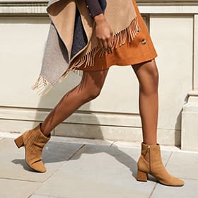 Woman wearing camel suede block-heel boots