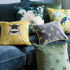 Patterned scatter cushions on teal velvet sofa