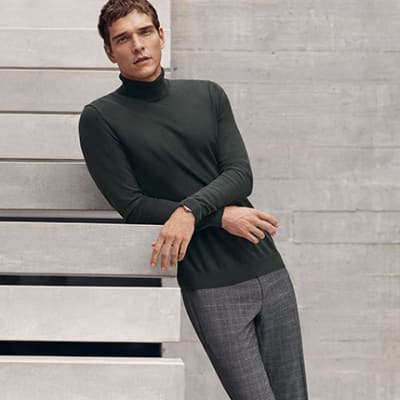 Man wearing roll-neck jumper and smart trousers