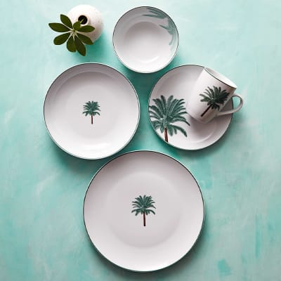 Palm-design dinner plate, pasta bowl, cereal bowl, side plate and mug, with bud vase on turquoise table