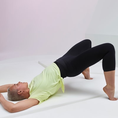 Woman lying down in Go Balance cropped yoga leggings and yellow T-shirt