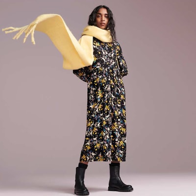Woman wearing oversized scarf and patterned midi dress