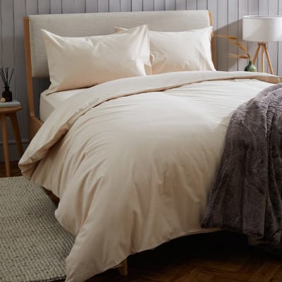 Double bed with pale pink cotton duvet cover and bedding