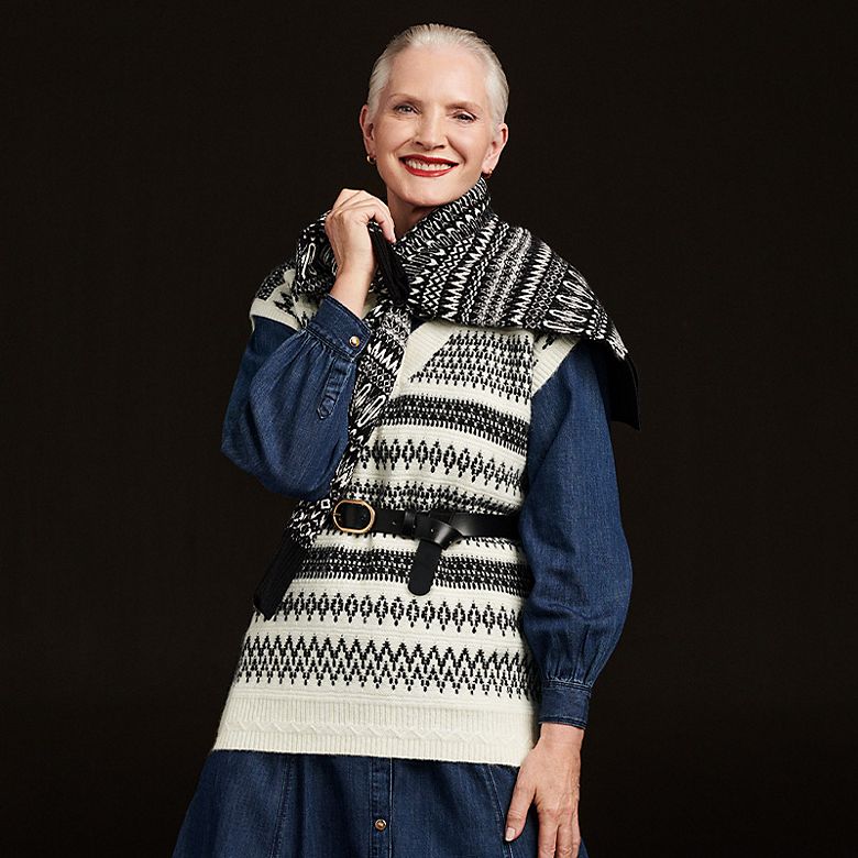 Woman wearing black and white Fair Isle sweater vest. Shop sleeveless knitwear  