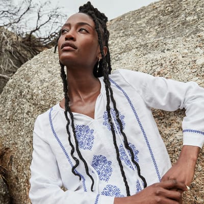 Women wearing a white patterned linen top. Visit the Linen Shop.  