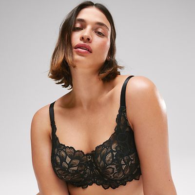 Woman wearing cream bra and black trousers. Shop fuller bust bras.