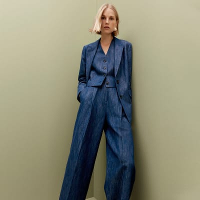 Woman wearing a blue blazer, matching trousers and waistcoat. Shop women’s new in 