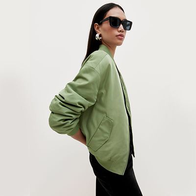 Woman wearing a green bomber jacket. Shop all coats and jackets.  