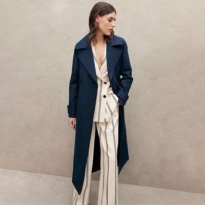 Woman wearing a navy trench coat. Shop all coats and jackets