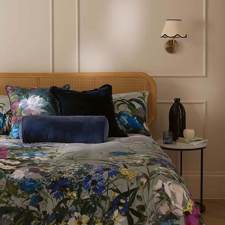 Bed with a floral duvet cover and striped cushion. Shop new-in homeware and furniture. 