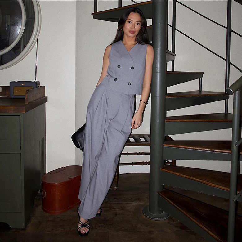 Instagram star Vanessa Rose Blair wears grey double-breasted waist coat and grey pleated wide-leg trousers. Shop women’s waistcoats 