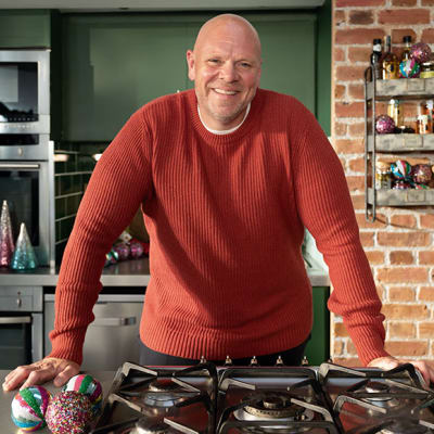 Tom Kerridge smiling and wearing a red jumper