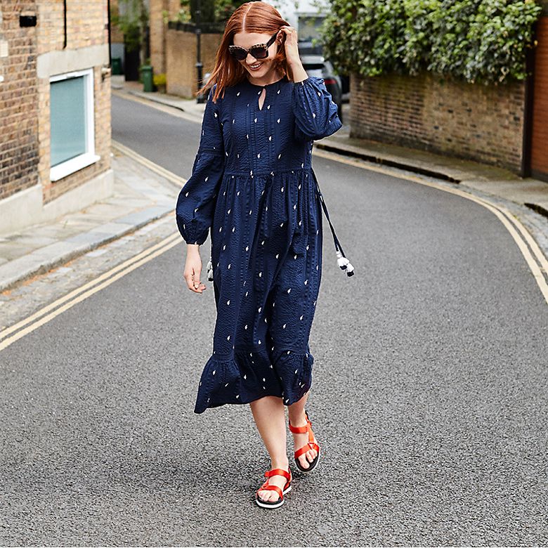 Woman wearing a navy embroidered midi dress