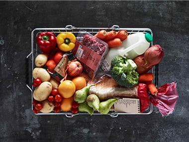 Shopping basket filled with fruit, vegetables, meat, bread and milk