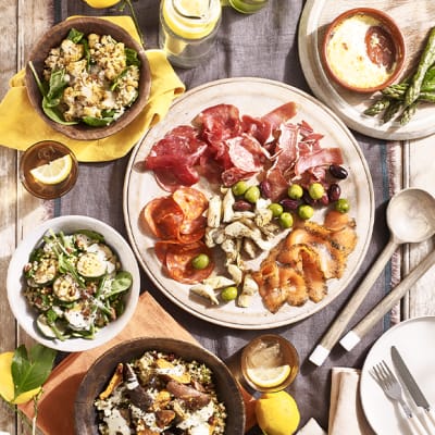 A garden table filled with charcuterie and salads