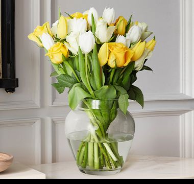 A vase filled with the meadow rose and tulips bouquet