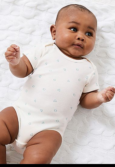 Baby wearing white and green cotton short-sleeved bodysuit. Shop now