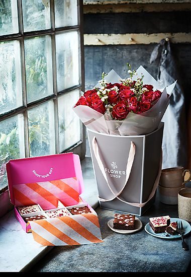 Gift bag of red roses and box of chocolate and raspberry brownies