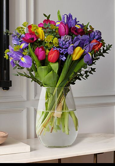 Bouquet of seasonal blooms including tulips and hyacinths in a glass vase