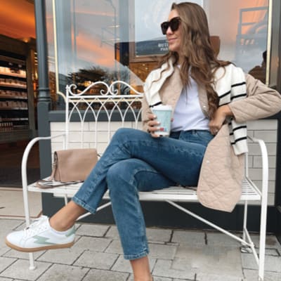 Clémentine MacNeice wearing Ivy skinny jeans, white trainers and puffer coat