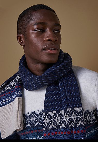 Man wearing navy Fair Isle knitted scarf. Shop now 