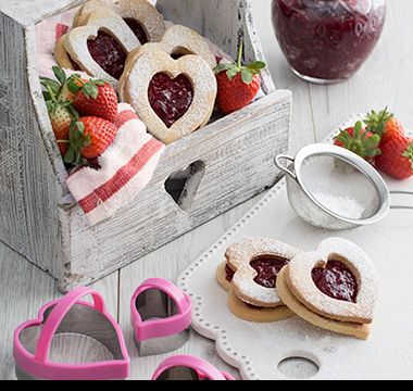 Lifestyle image showing heart-shaped cookie cutters and biscuits. Shop now 