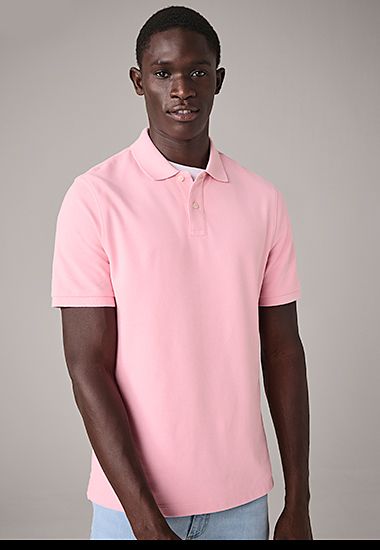 Man wearing light pink polo-shirt and light blue jeans. Shop now. 
