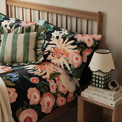 Bed with a floral duvet cover and striped cushion. Shop new-in homeware and furniture. 
