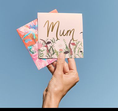 Hand holding Mother’s Day gift cards. Shop gift cards.