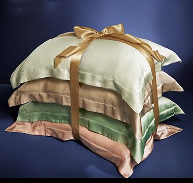 Stack of silk pillowcases tied with a ribbon. Shop silk pillowcases