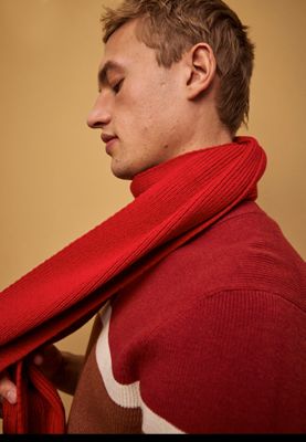 Man wearing red knitted scarf and red colour-blocked jumper. Shop men’s scarves