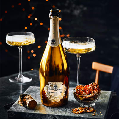 A bottle of Conte Priuli ORO prosecco with champagne glasses