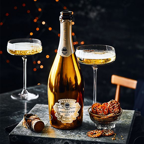 A bottle of Conte Priuli ORO prosecco with champagne glasses