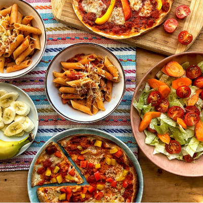 Tortilla pizzas, salad, pasta dishes, and sliced banana