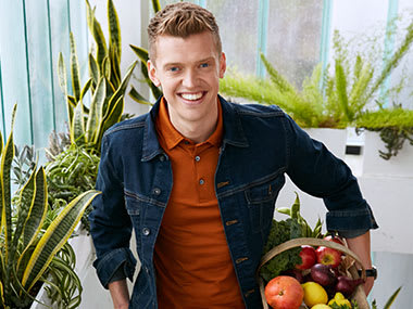 Chef Chris Baber carrying a basket of fresh produce