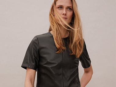 Woman wearing an Autograph black leather top