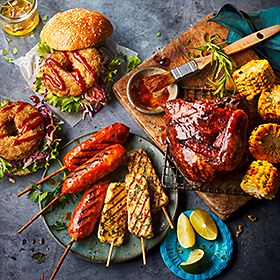 Range of M&S barbecue food including halloumi kebabs and a hog roast doughnut burger