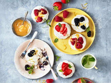 A selection of berry-topped mini pavlovas