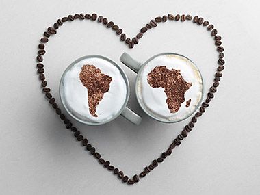 Two mugs with an Africa and South America pattern in cappuccino foam surrounded by a coffee bean heart for fairtrade coffee for fairtrade fortnight